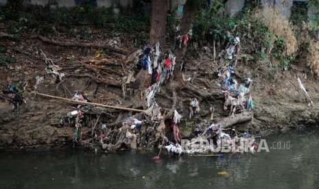 Sejumlah sampah plastik tersangkut di akar pohon yang terdapat pada aliran Sungai Ciliwung di kawasan Kebon Baru, Tebet, Jakarta, Jumat (7/9).