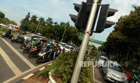 Sejumlah kendaraan saat menunggu lampu lalu lintas di Jalan Medan Merdeka Selatan, Jakarta, Jumat (30/11).