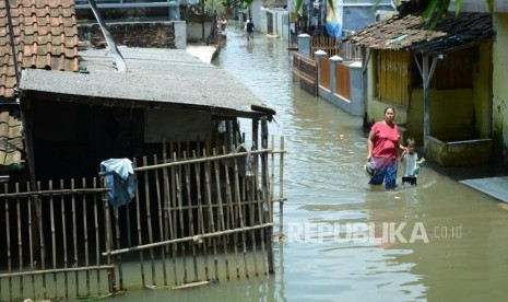 Banjir Bandung Selatan. Penduduk berjalan jalan kampung disebuah pemukiman yang telah terendam banjir, di Kecamatan Baleendah, Kabupaten Bandung, Senin (25/2).