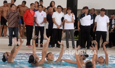 Presiden Joko Widodo (kedua kiri) didampingi Ketua Umum Persatuan Renang Seluruh Indonesia Anindya Bakrie (ketiga kiri), Ketua Pelaksana INASGOC Erick Thohir (kiri), Wakil Gubernur DKI Jakarta Sandiaga Uno (keempat kiri), Menteri PUPR Basuki Hadimuljono (ketiga kanan), Menkeu Sri Mulyani (kedua kanan) dan Menpora Imam Nahrawi (kedua kanan) meninjau stadion aquatik saat peresmiaan empat venue Asian Games di Kompleks Gelora Bung Karno, Jakarta, Sabtu (2/12).