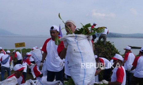 Karyawan Perum Jasa Tirta II bersama-sama memasukkan eceng gondok ke dalam karung pada  acara Gerakan Bersihkan Air dan Menjaga Kesinambungan Sumber Air untuk merayakan Hari Air Dunia ke 27 dan HUT BUMN RI ke 21 di Pelabuhan Biru, Waduk Jatiluhur, Rabu (10/4).