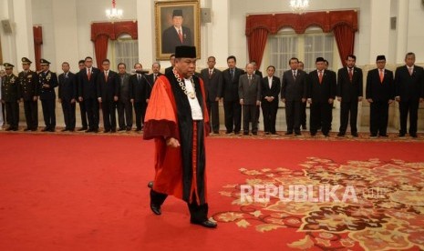 Pelantikan Hakim MK. Hakim Konstitusi Arief Hidayat menuju meja penandatanganan berita acara usai membaca sumpah jabatan di depan Presiden Joko Widodo saat pelantikan Hakim Konstitusi di Istana Negara, Jakarta, Selasa (27/3).