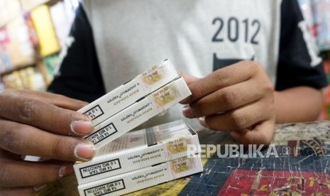 Pedagang menunjukan bungkus rokok bercukai, ilustrasi. Tahun ini panerimaan cukai ditargetkan sebesar Rp 172,9 triliun.