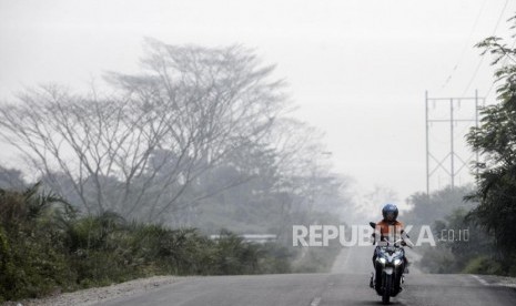 Pengendara motor melintas saat kabut asap kebakaran hutan dan lahan menyelimuti Pekanbaru, Riau.