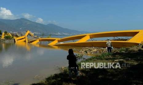 Sejumlah warga melihat kondisi Jembatan Ponulele yang rusak di kawasan Pantai Talise, Palu, Sulawesi Tengah, Senin (1/10).