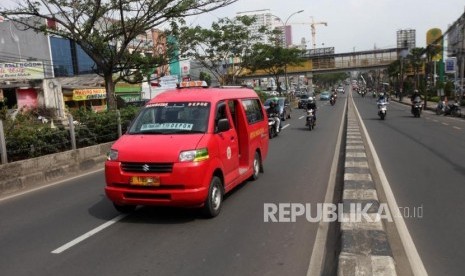 Sejumlah kendaraan motor dan angkutan kota (angkot) melintas di jalur cepat Jalan Margonda, Depok, Jawa Barat, Jumat (2/2).