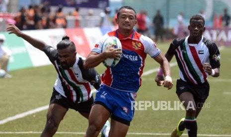 Pemain rugby Indonesia Andika Yudistira P. Hendra Prihatin (tengah) berlari membawa bola dibayangi pemain rugby Uni Emirat Arab pada babak perebutan posisi 9-12 cabang olahraga rugby Asian Games 2018 di Gelora Bung Karno, Jakarta, Sabtu (1/9).