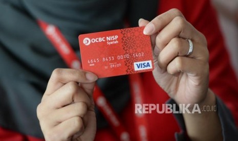  Petugas menunjukan kartu debit OCBC NISP Syariah. Bank OCBC NISP resmi meluncurkan Tabungan Emas.