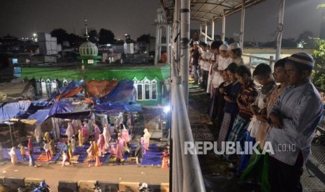 Umat muslim menunaikan ibadah Shalat Tarawih pertama di Atas JPO Pasar Gembrong, Jakarta, Ahad (5/5).