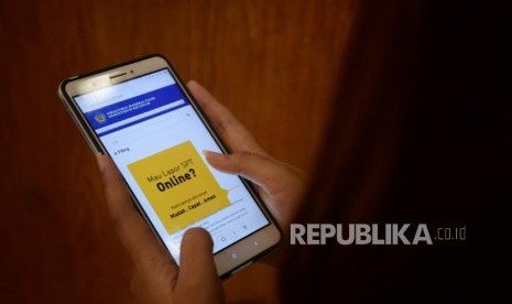 Seorang wajib pajak mencari informasi mengenai pengisian SPT secara online di Jakarta, Jumat (9/3).