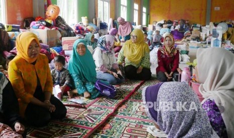 Direktur Keuangan BPJS Ketenagakerjaan Evi Afianti (kiri) berdialog dengan korban bencana longsor di kabupaten Kuningan, Jawa barat di tempat penampungan korban di Desa Pinara, Kecamatan Ciniru,Kuningan Jawa barat, Kamis (8/3).