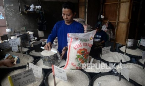 Pedagang melayani konsumen di salah satu agen penjual beras di Kawasan Manggarai, Jakarta, Ahad (4/3).