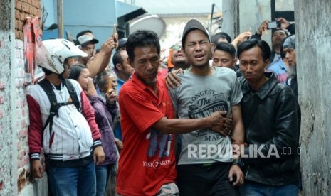 Seorang keluarga korban berusaha ditenagkan saat peristiwa kebakaran di permukiman padat penduduk di Kampung Karees Kulon RW 06, Kelurahan Malabar, Kecamatan Lengkong, Kota Bandung, Kamis (3/5).