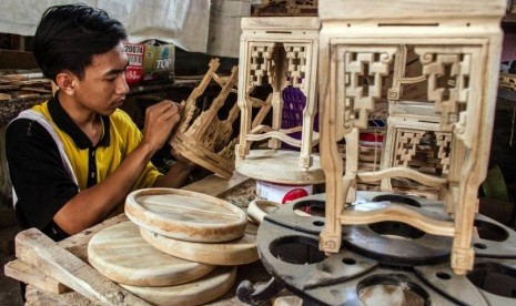 Pekerja menyelesaikan pembuatan kerajinan dekorasi rumah dari limbah mebel kayu jati di sebuah industri rumahan di Desa Klampok, Grobogan, Jawa Tengah, Jumat (24/11).