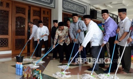 Wakil Ketua Dewan Masjid Indonesia Syafruddin saat mengepel masjid pada acara bersih-bersih masjid di Masjid Al-Mabrur, Asrama Haji Pondok Gede, Jakarta, Ahad (28/4).