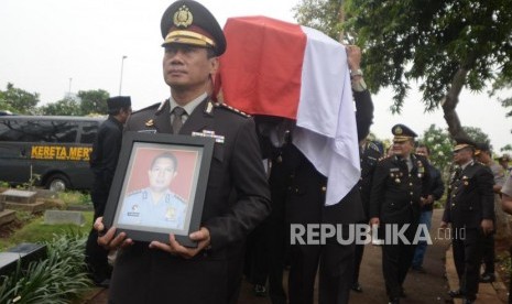 Anggota kepolisian membawa foto dan peti jenazah saat pemakaman korban jatuhnya pesawat Lion Air PK-LQP, AKBP Sekar Maulana di TPU Karet Bivak, Jakarta, Kamis (8/11).