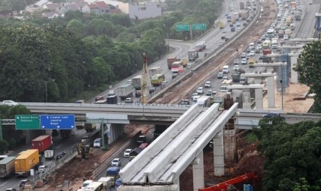 Kendaraan melintas di samping salah satu lokasi pengerjaan pembangunan infrastruktur di ruas Jalan Tol Jakarta-Cikampek, di Bekasi, Jawa Barat, Selasa (19/12).