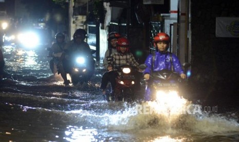 Pengendara motor melintasi genangan air saat terjadi banjir di kawasan Mampang, Jakarta, Kamis (13/12).