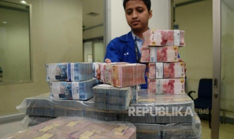 Petugas menata uang kertas rupiah di ruang penyimpanan uang 