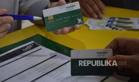 Karyawan Bank Syariah Mandiri Thamrin melayani nasabah yang melakukan penukaran kartu Mandiri Syariah berlogo Gerbang Pembayaran Nasional (GPN) di acara Silaturrahim dan Berbagi Keceriaan (Siaran) Mandiri Syriah, di Jakarta,Ahad (28/10).