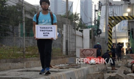 Tamasya Trotoar. Aktivis Koalisi Pejalan Kaki melakukan aksi simpatik di Kawasan Farmawati, Jakarta, Jumat (1/3).