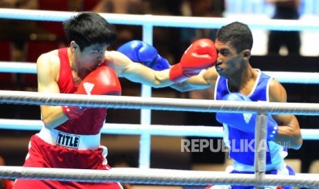 Petinju Putra Indonesia Blasius Kali Mario (biru) saling melancarkan pukulan saat berhadapan dengan petinju China Wei Tu Po saat tarung pada kelas 49 kg, di ajang Invitation Tournament Asian Games 18 di Jakarta, Ahad (11/2).