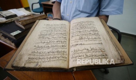 Petugas Museum Bayt Alquran menunjukan mushaf Alquran berbahan daluang ( kayu pohon daluang) di Museum Bayt  Alquran, Jakarta,Rabu (5/12).