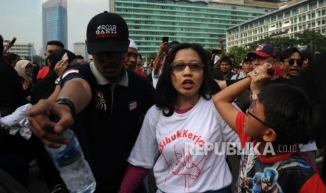 Peserta Aksi 2019 Ganti Presiden bertemu denga peserta jalan santai dia sibuk kerja di hari bebas kendaraan bermotor di Kawasan Bundaran Hotel Indonesia, Jakarta, Ahad (29/4).