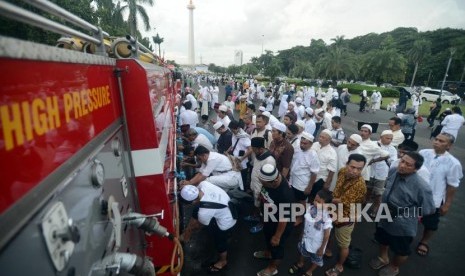 Para peserta Munajat 212 mengambil air wudhu.