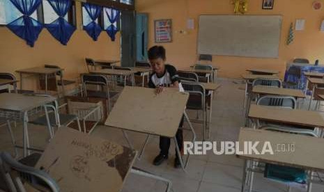 Aktivitas Pendidikan : Siswa SMP Negeri 6 mengangkat meja belajar saat melihat kondisi sekolahnya di Jalan Dewi Sartika, Palu, Sulawesi Tengah, Senin (8/10).