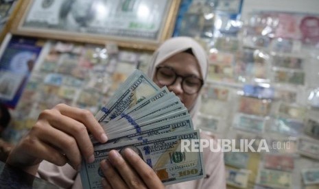 Cadangan Devisa Susut. Pegawai menghitung mata uang dolar AS di jasa penukaran mata uang, Jakarta. ilustrasi