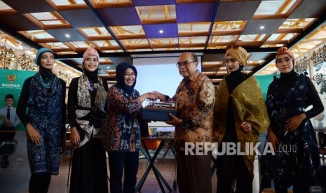 Ketua Badan Amil Zakat Nasional (Baznas) menerima cinderamata dari Direktur Administrasi dan Keuangan PT Railink Indah Suryandari didampingi sejumlah model sebelum acara peragaan busana di Stasiun BNI City, Jakarta, Kamis (2/5).