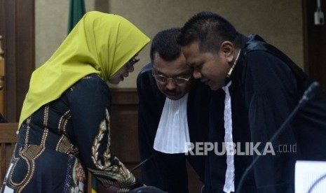 Mantan anggota DPR RI wakil ketua Komisi VII, Eni Maulani Saragih berdiskusi dengan penasehat hukum saat  menjalani sidang  perdana di Pengadilan Tindak Pidana Korupsi, Jakarta, Kamis (29/11).