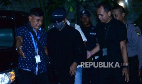 Ketua Umum Partai Persatuan Pembangunan (PPP) Romahurmuziy (mengenakan masker dan bertopi)  digiring petugas setibanya di gedung KPK, Jakarta, Jumat ( 15/3).