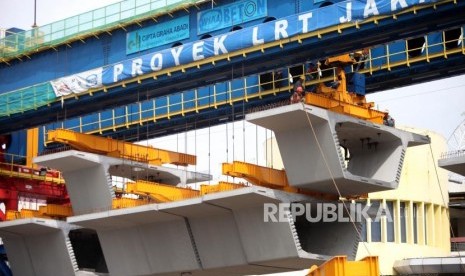 Pekerja menyelesaikan pembangunan proyek Light Rail Transit (LRT) Atau kereta api ringan dikawasan Kelapa Gading, Jakarta, Ahad (14/1).