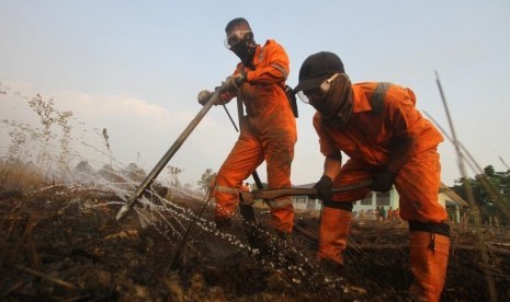 Satgas Kebakaran hutan dan lahan (Karhutla) dari Dinas Kehutanan Kalsel menggunakan alat suntik gambut (Sunbut) saat berupaya memadamkan kebakaran lahan gambut di kawasan Syamsudin Noor, Banjarbaru, Kalimantan Selatan, Sabtu (14/9/2019).