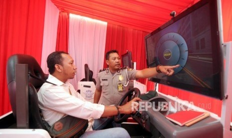 Warga melakukan tes simulator sim pada kegiatan pembuatan SIM A Umum kolektif untuk pengemudi angkutan taksi online dan konvensional di kawasan Gelora Bung Karno (GBK), Senayan, Jakarta, Ahad (25/2).