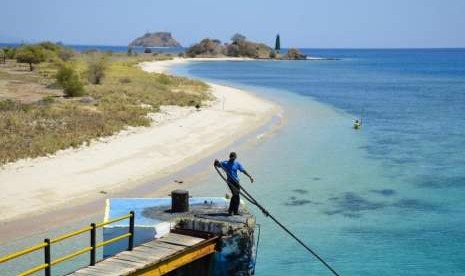 Seorang laki-laki menarik tali tambatan kapal feri usai melintasi Selat Alas dan berlabuh di pelabuhan Poto Tano, Taliwang, Sumbawa Barat, NTB, Minggu (10/9).