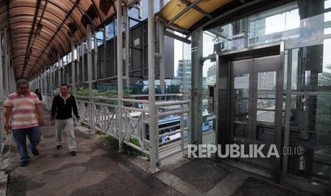 Warga melintas di samping lift halte busway Tosari yang rusak di Jalan MH Thamrin, Menteng Jakarta Pusat, Jumat (17/11).