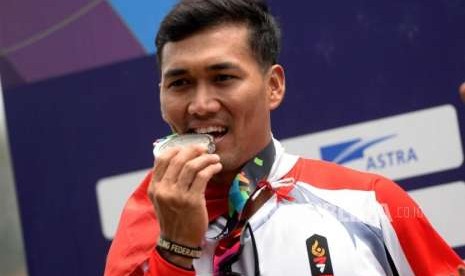 Atlet Sepeda BMX Putra Indoensia I Gusti Bagus Saputra menggigit medali usai pertandingan final cabang sepeda BMX putra Asian Games 2018 di Pulomas Internasional BMX Center, Jakarta, Sabtu (25/8).