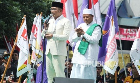 Pasangan calon gubernur dan wakil gubernur Jawa Barat Ridwan Kamil (kiri) dan Uu Ruzhanul Ulum menyampaikan orasi pilotik di depan massa pendukungnya di pelataran parkir Stadion Sidolig, Kota Bandung, Selasa (9/1).