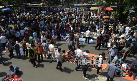 Sejumlah pedagang menggelar barang daganganya usai Shalat Jumat di halaman Masjid Cut Meutia, Jakarta, Jumat (26/7).