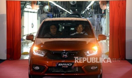 Presiden Director PT Honda Prospect Motor (HPM) Takehiro Watanabe bersama Menteri Perindustrian Airlangga Hartarto mengendari mobil All New Honda Brio saat seremoni produksi perdana All New Honda Brio untuk pasar ekspor dan perayaan ulang tahun PT Honda Prospect Motor ke-20 di Pabrik Karawang, Jawa Barat, Selasa (26/3).