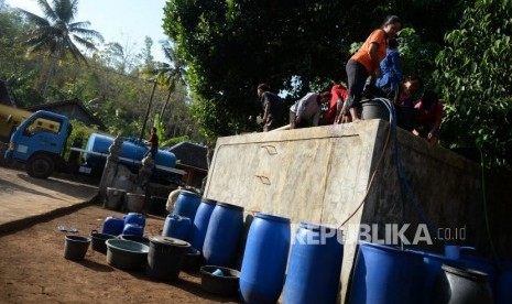 Kesulitan Air Bersih. Warga mengambil air saat pengiriman air bersih dengan tangki di Dusun Papringan, Tileng, Gunungkidul, Selasa (25/6/2019).