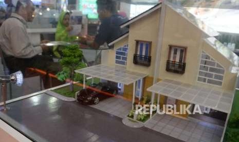 Penjaga stan menjelaskan tentang harga rumah dan fasilitasnya kepada calon konsumen saat pameran perumahan di Jakarta, Rabu (26/9).