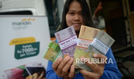 Penukaran Pecahan Rupiah. Nasabah usai menukarkan uang di mobil kas keliling Bank Syariah Mandiri di Lapangan IRTI Monas, Jakarta, Rabu (23/5).