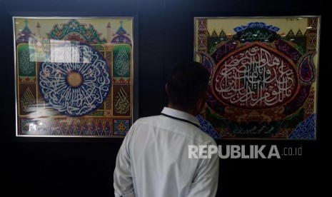 Pengujung melihat lukisan kaligrafi yang dipamerkan pada Festival Seni Kaligrafi Islam Indonesia di Gedung Bayt Al-Quran TMII, Jakarta, Senin (14/1).