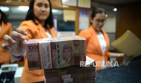 Officers count Rupiah in money exchange services, Jakarta.