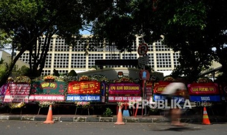 Pesepeda melintas di dekat karangan bunga yang terpasang di depan Gedung Komisi Pemilihan Umum (KPU), Jakarta, Ahad (21/4).