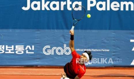 Melaju Ke Final. Petenis Ganda Campuran Indonesia Christopher Rungkat melakukan servis saat bertanding dengan pasangan  Jepang pada cabang tenis nomor ganda campuran di Komplek Olahraga Jakabaring, Palembang, Jumat (24/8).